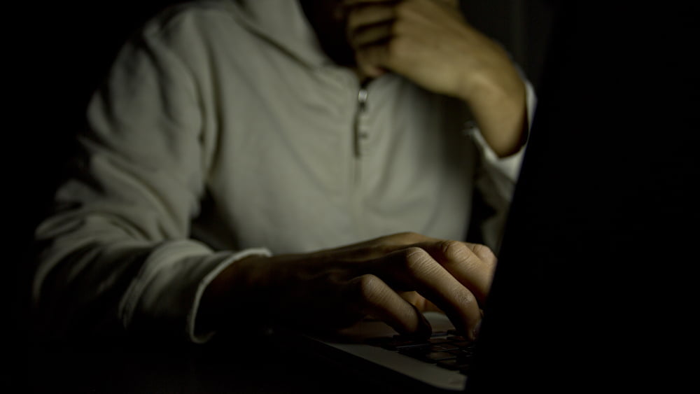 man on computer in dark